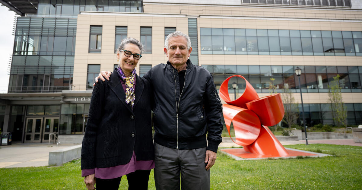 Corey Goodman stands with his arm around Carla Shatz as they pose together in front of the Li Ka Shing Center.