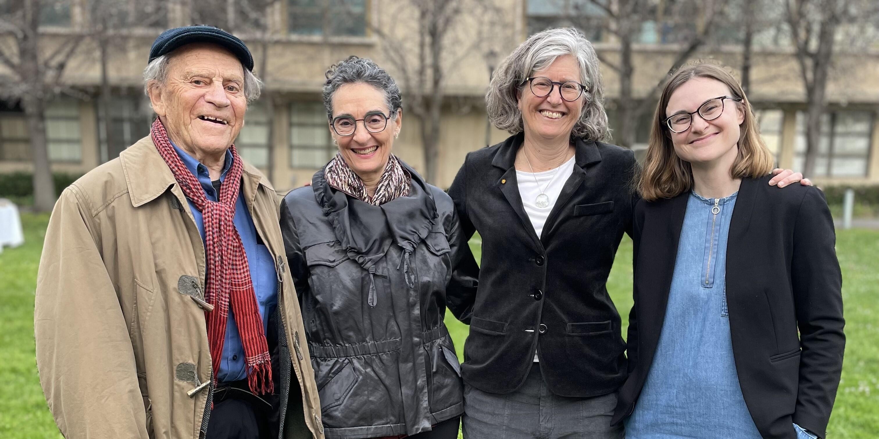 Torsten Wiesel, Carla Shatz, Marla Feller, and Anna Vlasits standing outside with their arms around each other, smiling.