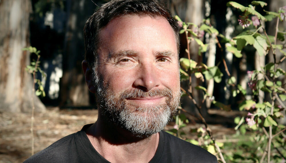 Headshot of Noah Whiteman in the woods.